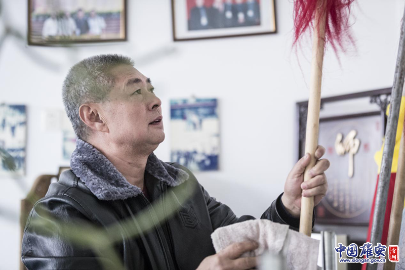 陳桂學(xué)擦拭著練功房中的兵器，這些兵器很多是父輩們留下來的。李鑫 攝